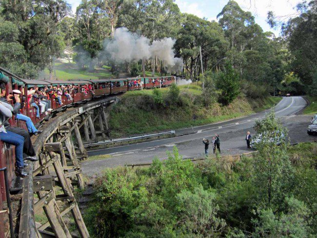 People wave and snap photos as the train goes by.