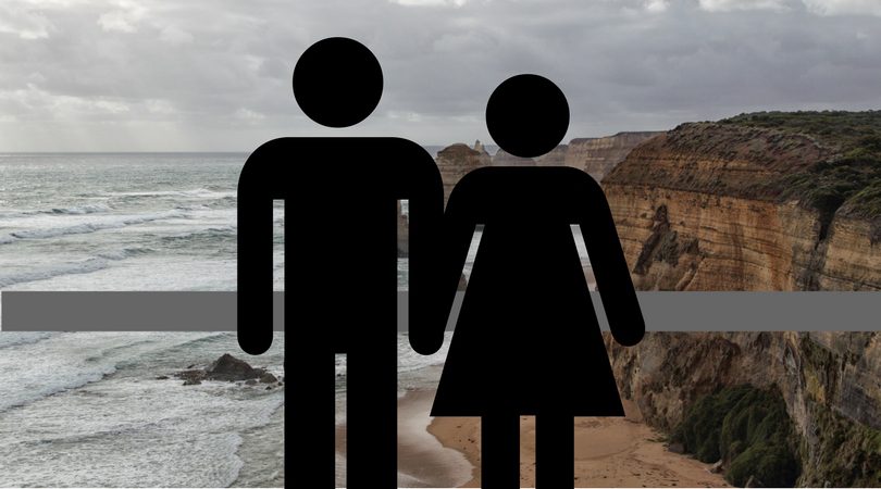 A male and female figure blocking the view of the Twelve Apostles.