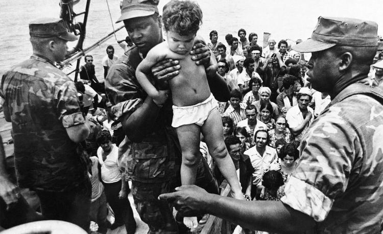 A U.S. Marine helps a child off one of the refugee boats during the Mariel Boatlift in 1980.