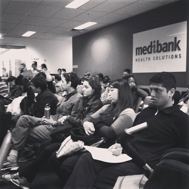 Immigrants in a waiting room waiting to get a medical assessment.