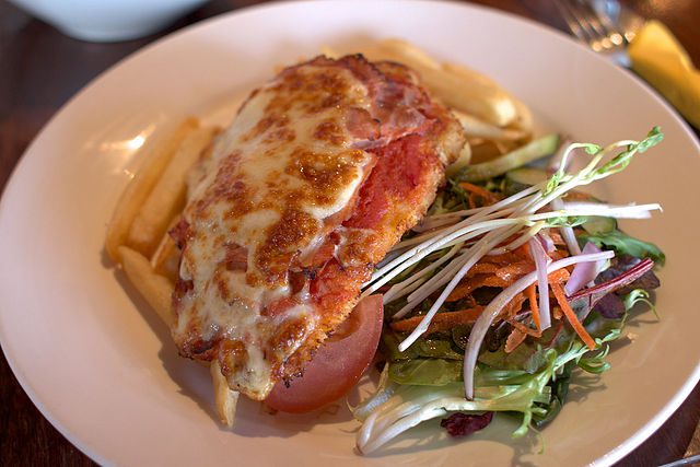 Chicken parma with chips and salad.