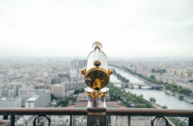 A telescope on a balcony looking over a city. Expat life.