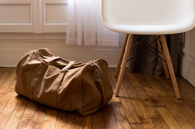 Between cultures. Suitcase on the floor.