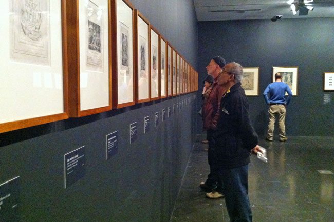 Visitors looking at William Blake's Illustrations of the Book of Job.