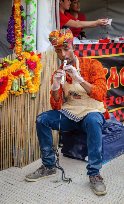 Man charming a rubber snake.