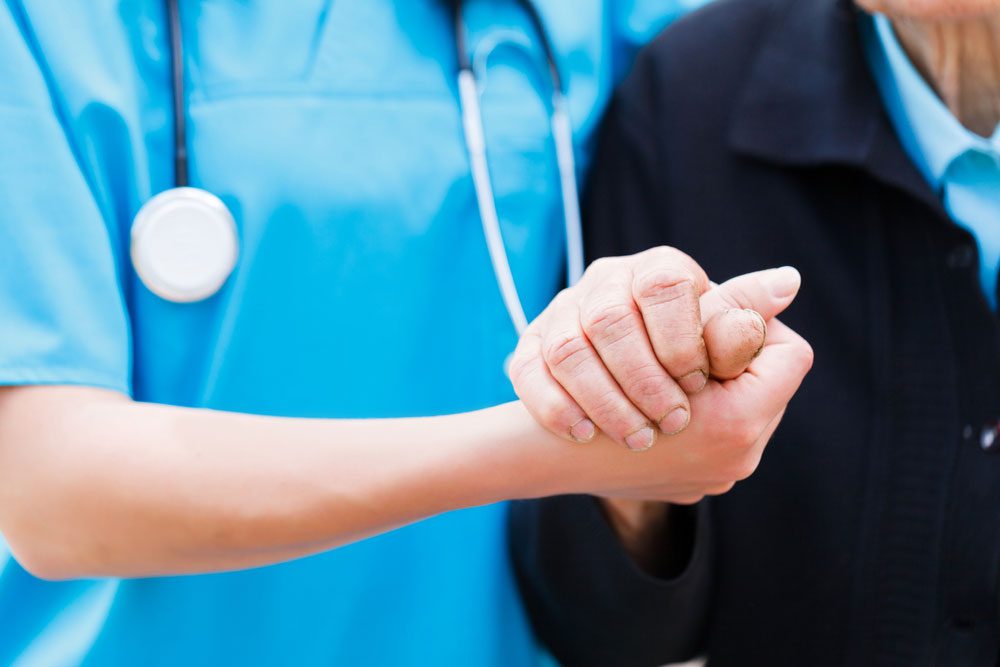 Health insurance - medical professional holding patient's hand.