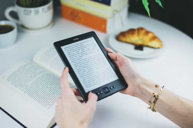 Woman reading on a Kindle. On Pagans and copyright infringement.