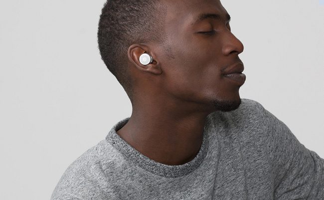 A man wearing Here One wireless earbuds.