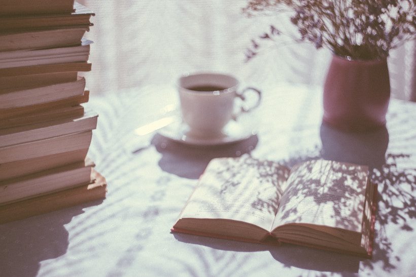 Stack of books and coffee. Best fiction books 2017.