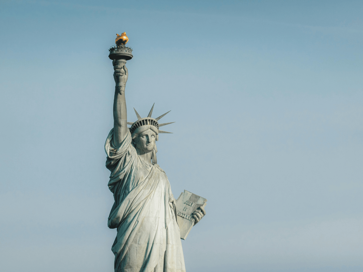 The Statue of Libery against a blue sky.