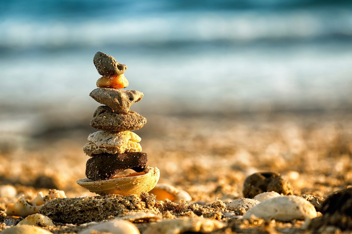 Balancing stones stacked on a beach.