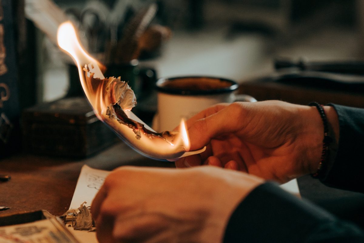 Person holding paper on fire