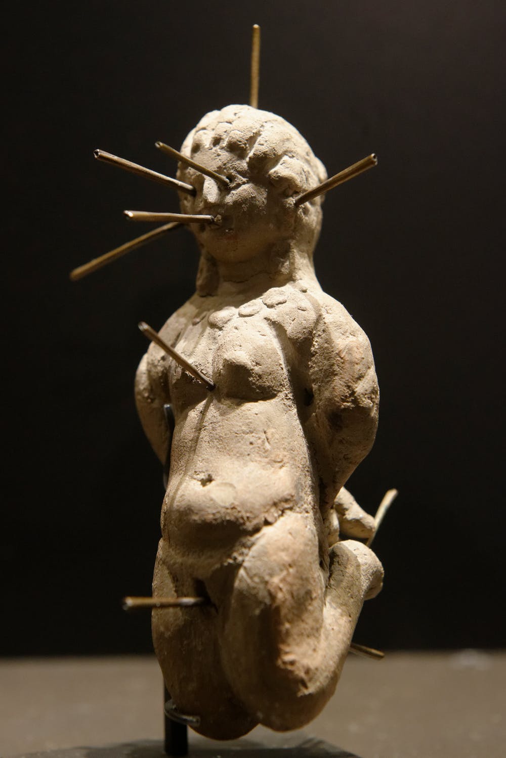 Erotic magic 4th century clay female figure pierced with thirteen needles.