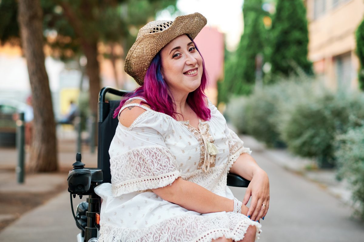 Woman with disabilities in a wheelchair looking at camera.