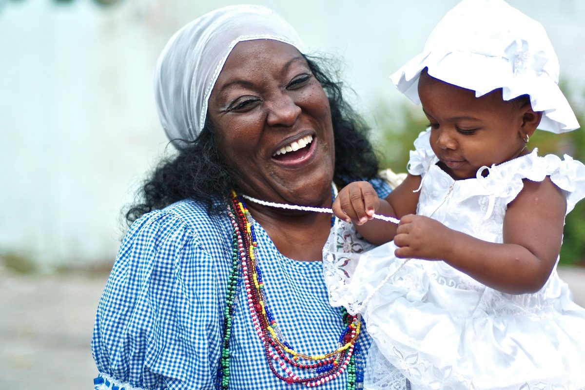 Cuban woman in Yemaya clothing holding baby.