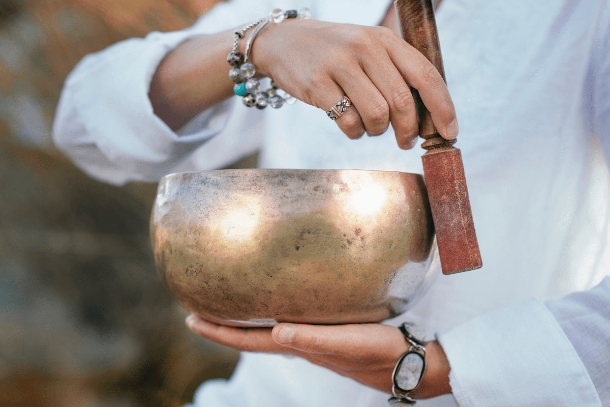 Female hands playing singing bowl.
