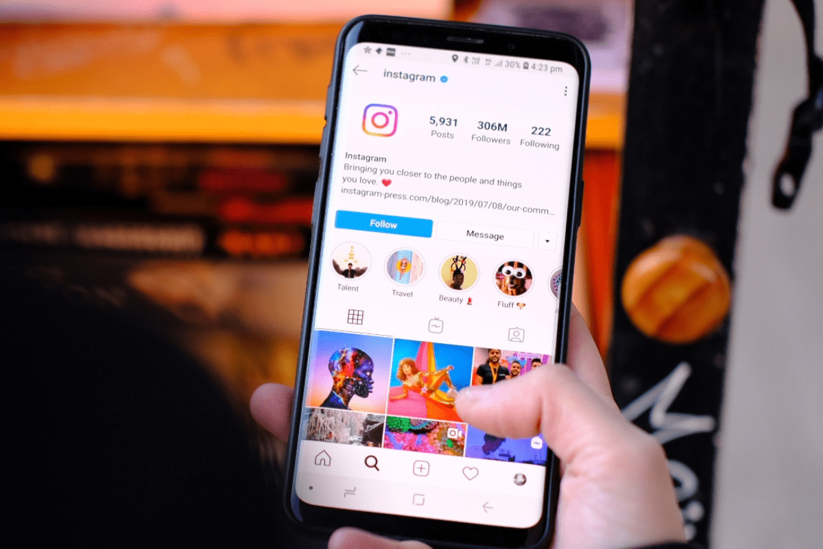 A hand holding a smartphone with Instagram on the screen.