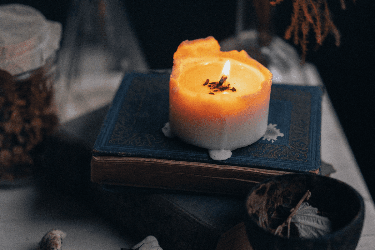 Lit candle on a book.