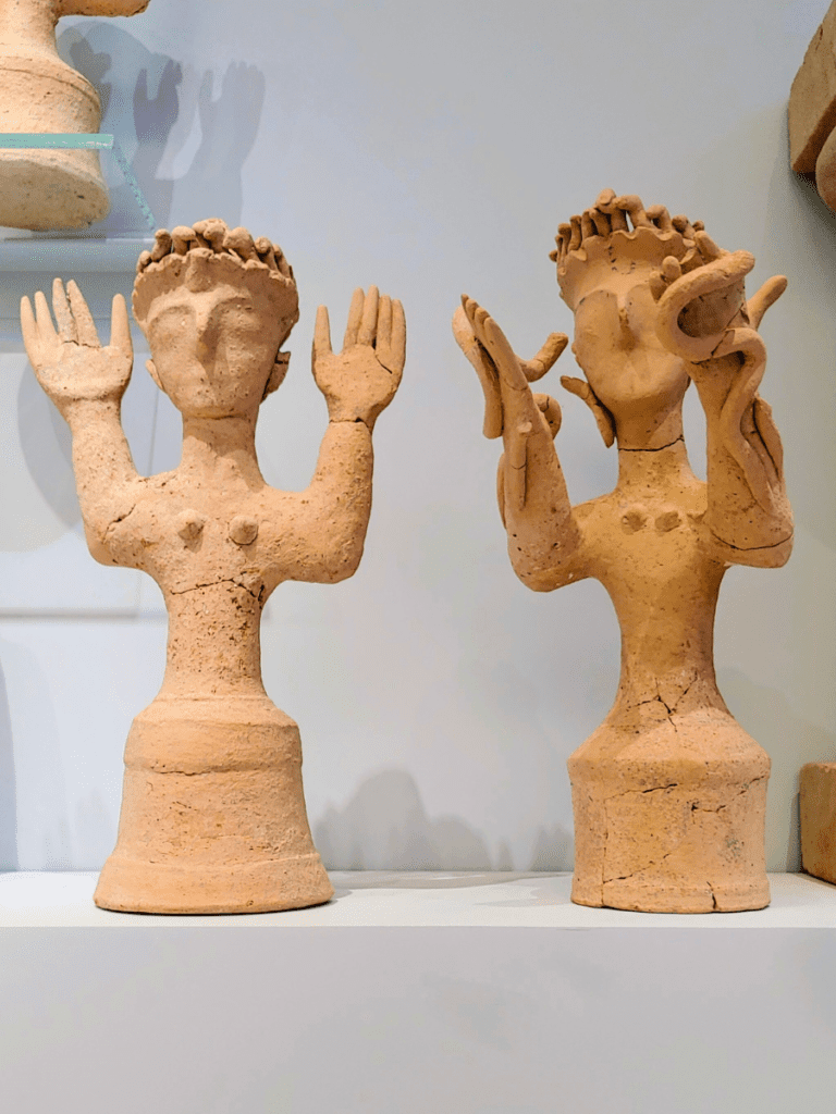 Clay figures of goddesses with upraised arms.