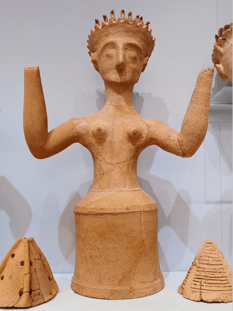 Clay figure of a goddess with upraised arms.
