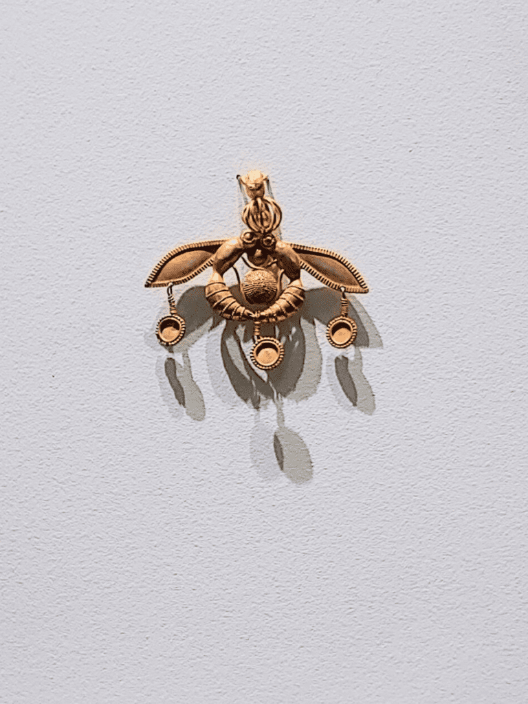 Gold pendant in the shape of two facing bees