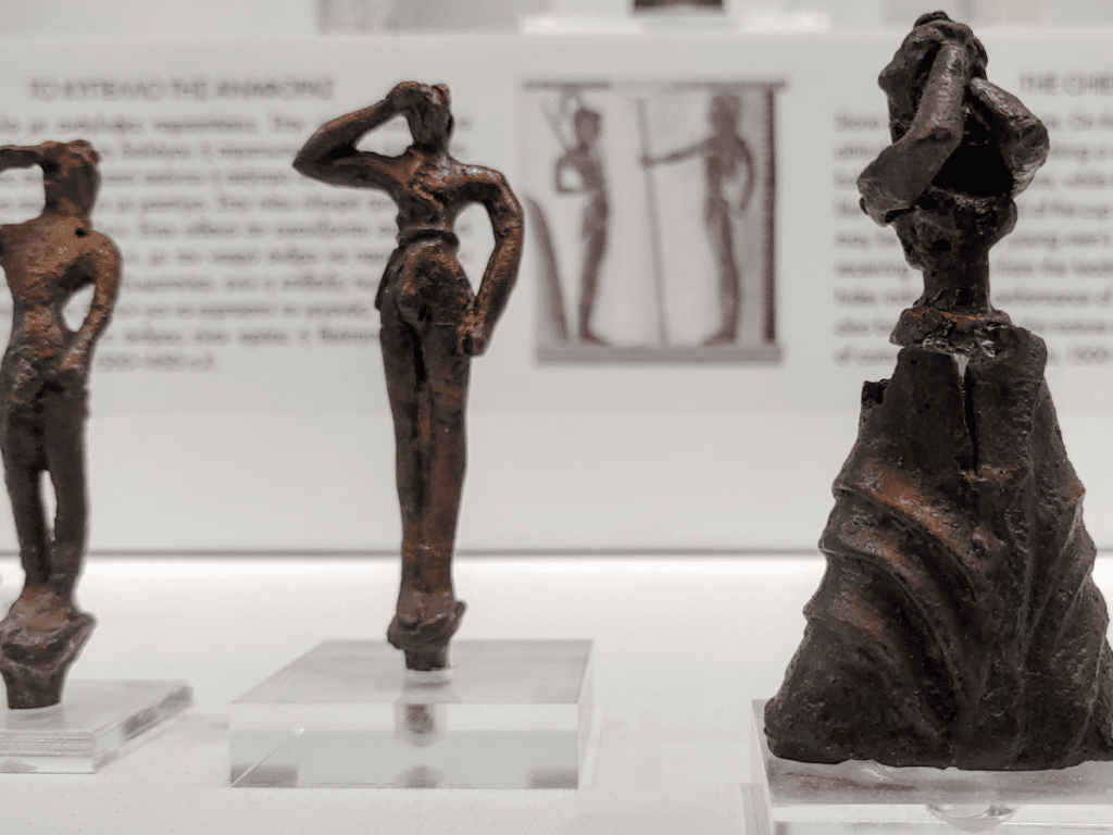 Three bronze male and female figurines.
