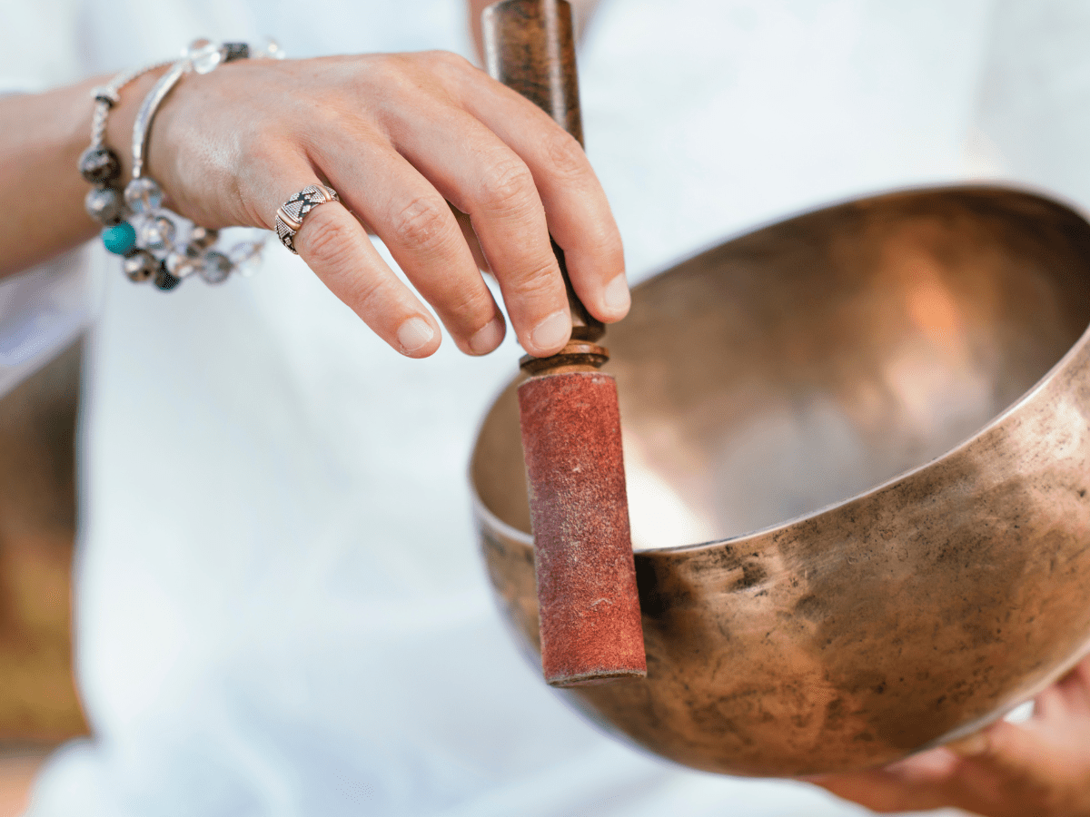 Female hand playing a singing bowl.