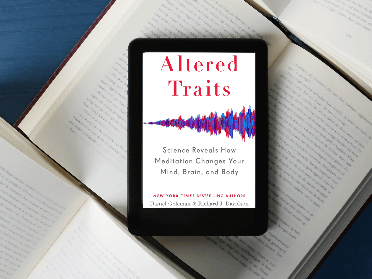 Altered Traits on a Kindle on top of open books.