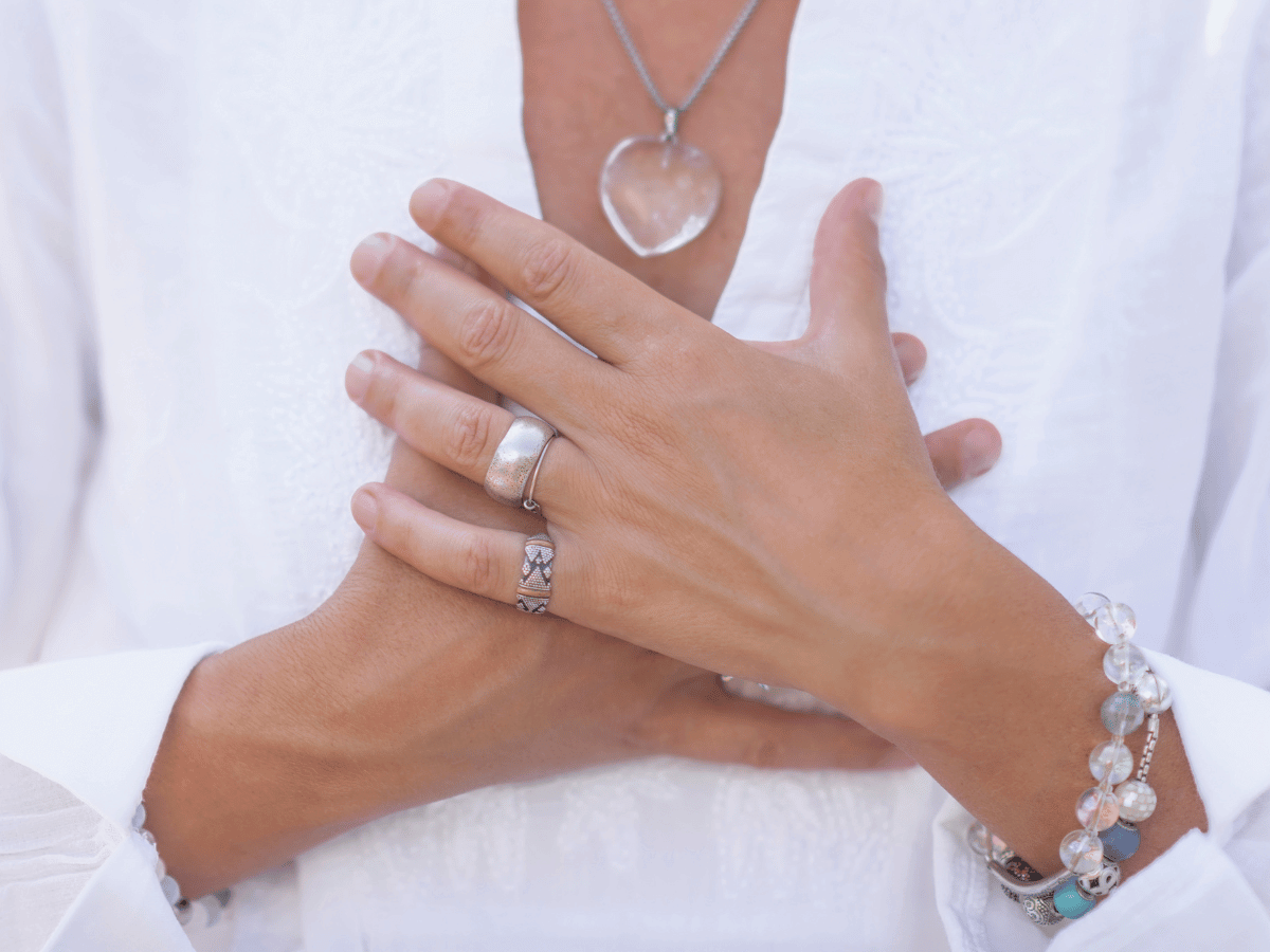 Female hands crossed over the heart.