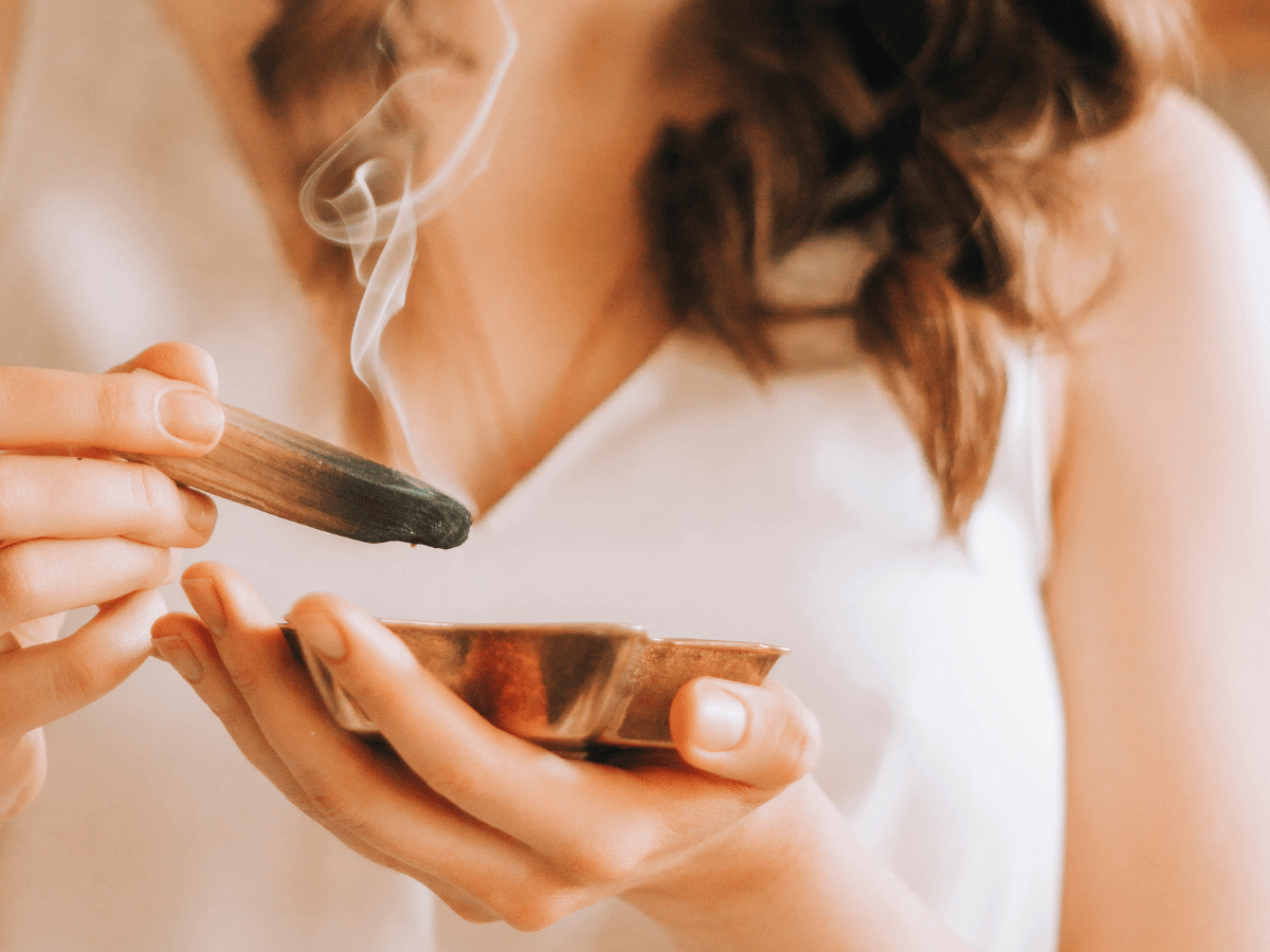 Woman with dark hair burning sandal stick