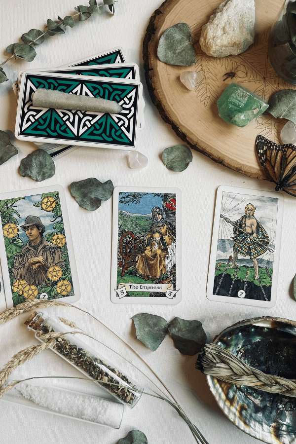 The Robin Wood tarot cards laid out surrounded by crystals and greenery.