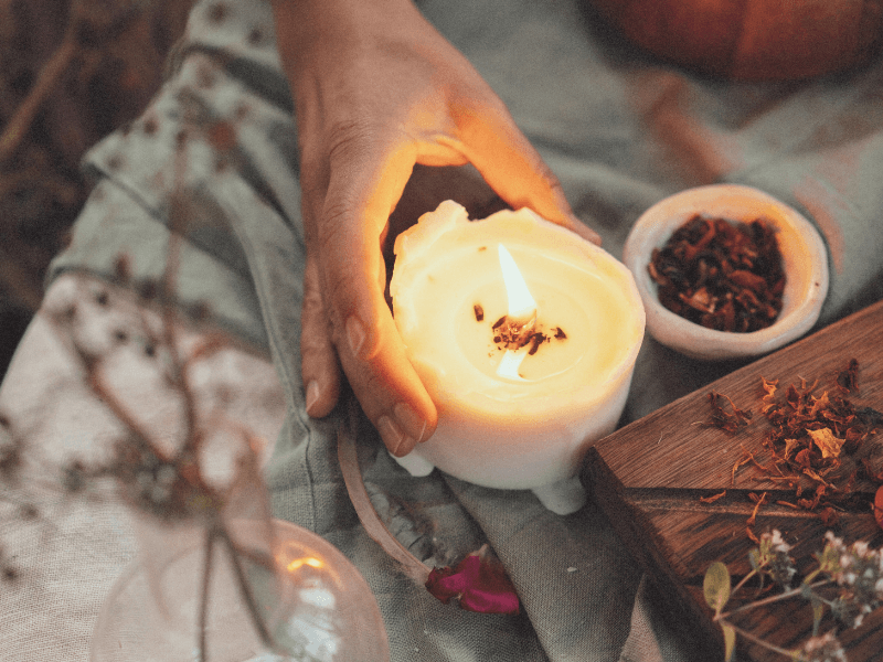 Hand holding a lit candle.