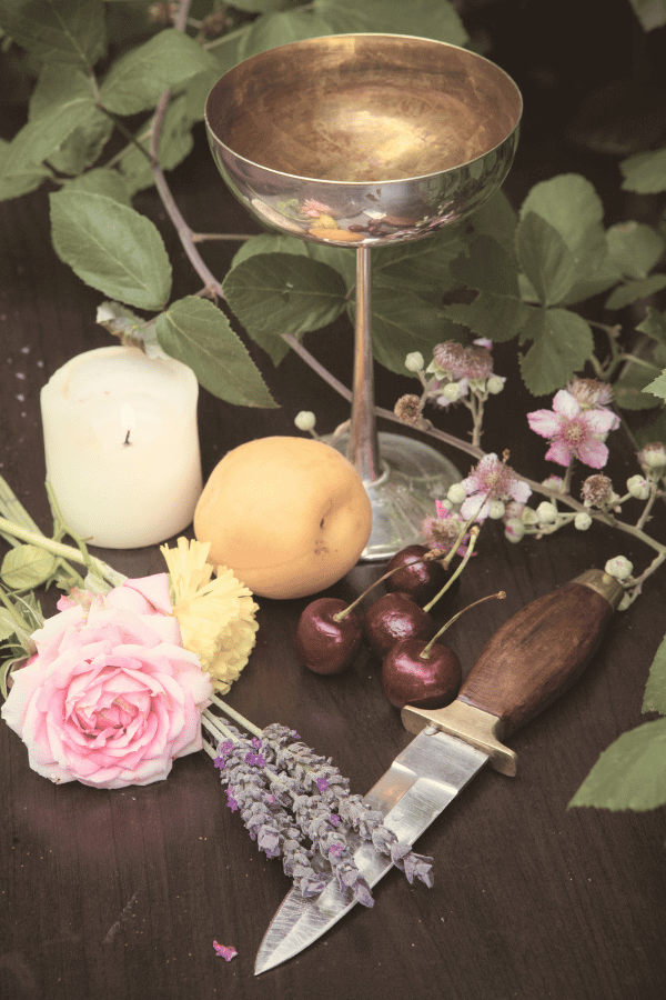 A Wicca altar with chalice, athame, and flowers.
