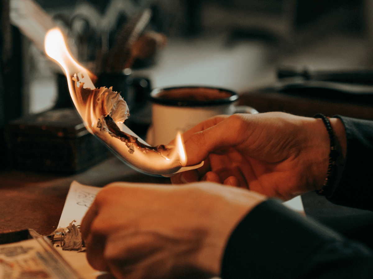 Hands setting paper on fire