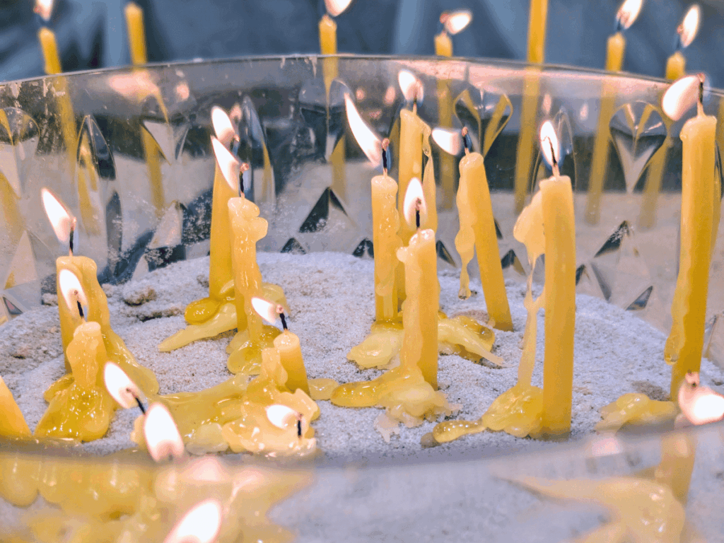 Candles burning in a bowl of sand.