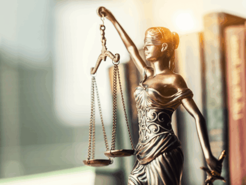 A figure of Themis as Lady Justice against a stack of books.