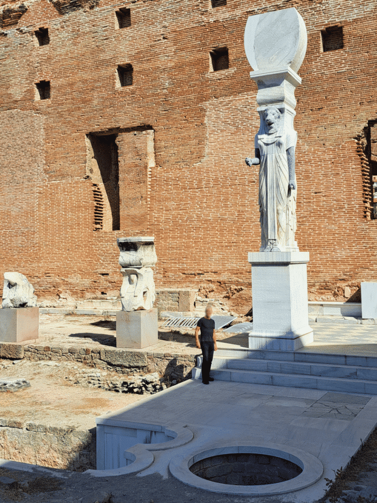 Reconstructed lion-headed figure towering above a visitor standing beside its pedestal at the Red Hall.